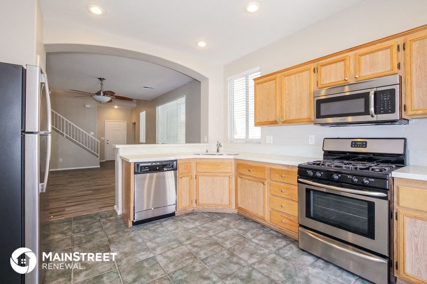 a kitchen with wooden cabinets and stainless steel appliances