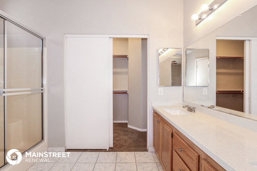 a bathroom with a shower and a sink and a mirror