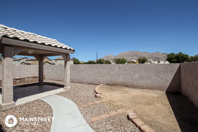 a covered patio with a stone wall and a pavilion