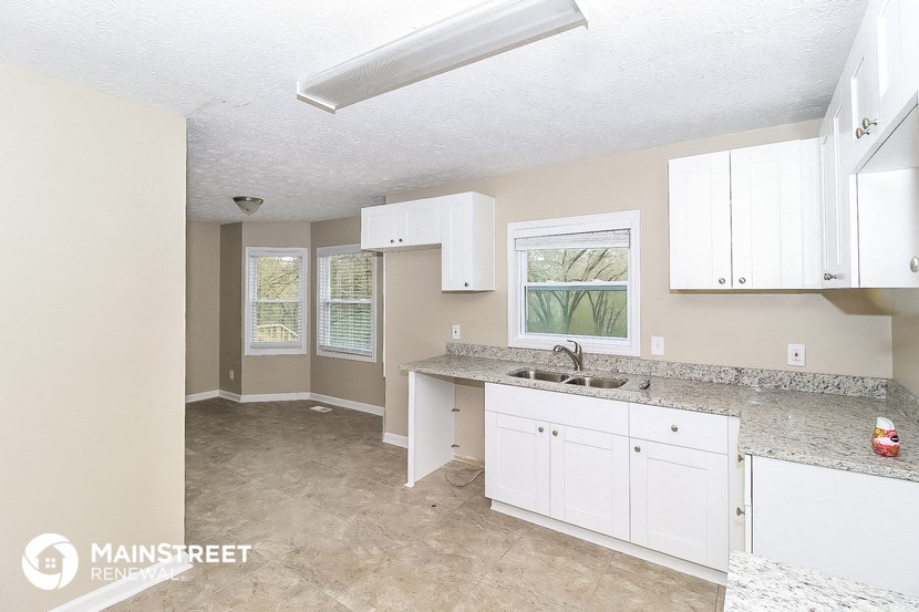 a kitchen with white cabinets and granite counter tops and a sink