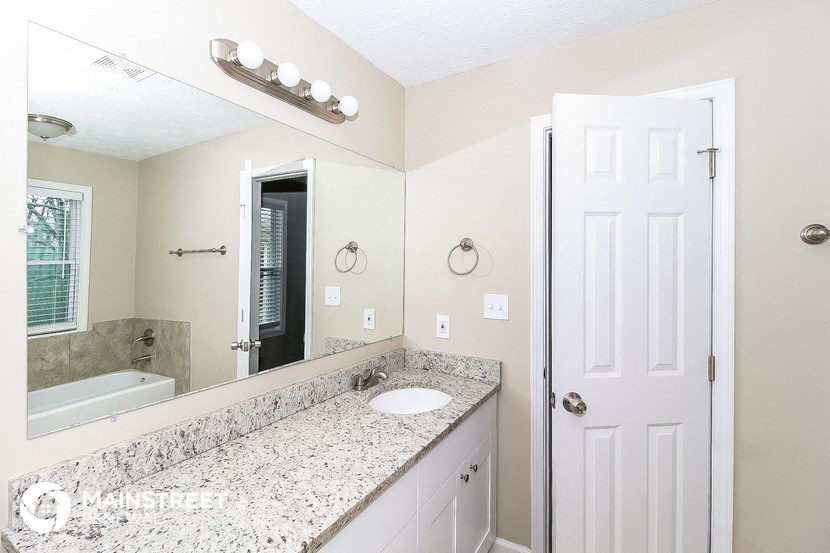 a bathroom with a sink and a mirror and a tub