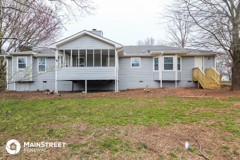 the back of a house with a yard and a deck