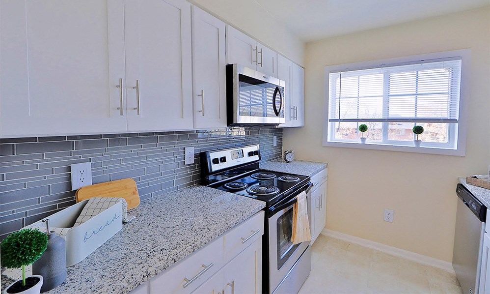 a kitchen with white cabinets and a stove and a microwave