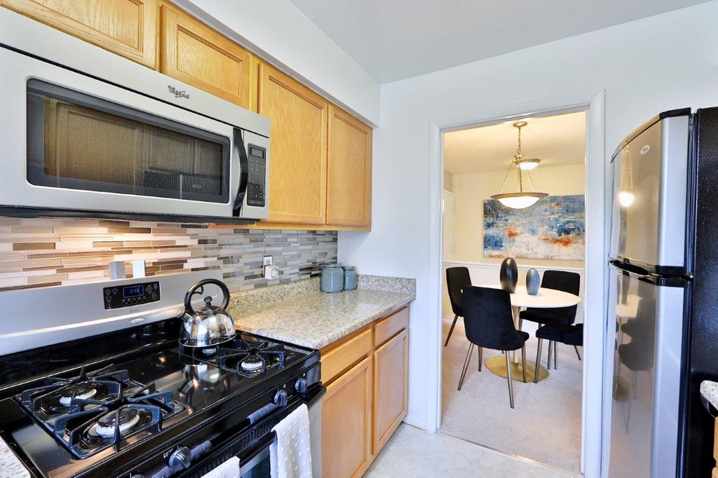 a kitchen with a stove and a microwave  and a dining room