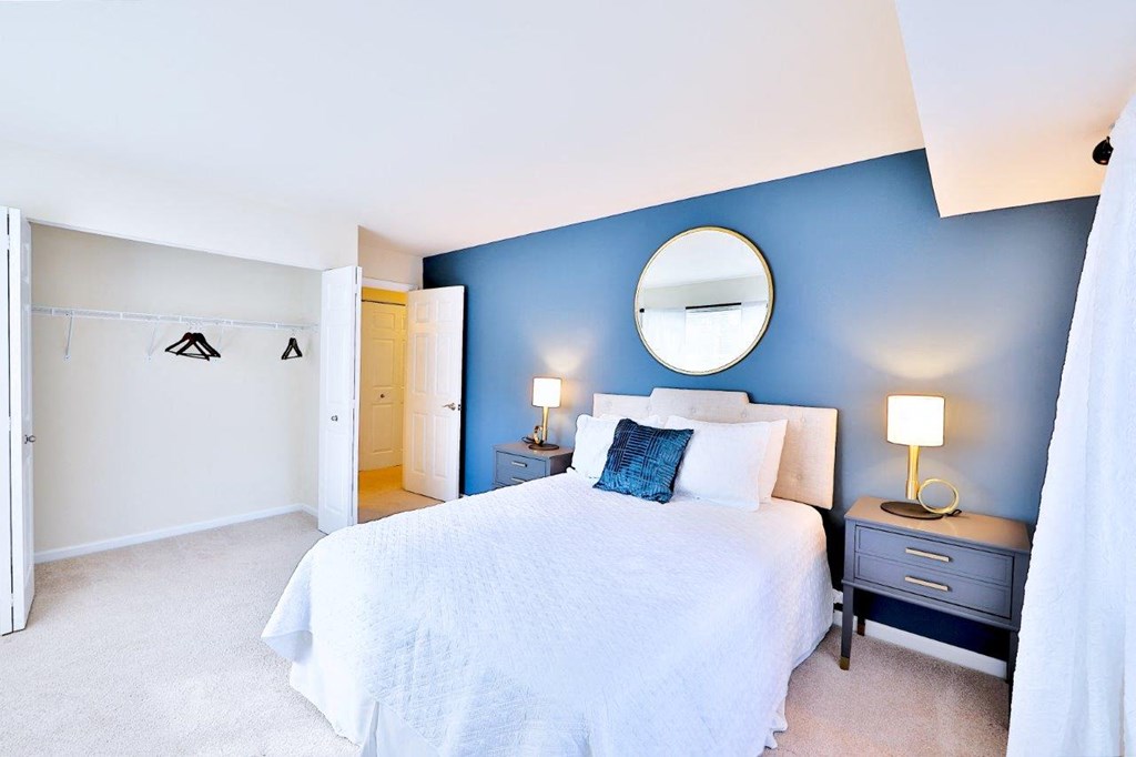 a bedroom with a white bed and a blue wall