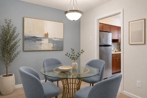 A dining room with a glass table and blue chairs.