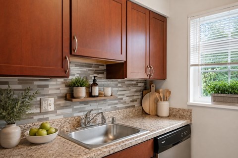 A kitchen with brown cabinets and a stone backsplash.