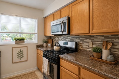 A kitchen with wooden cabinets and a black stove top.