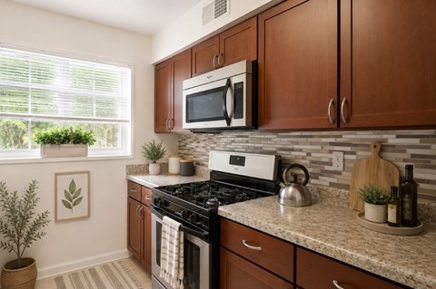 A kitchen with brown cabinets and a white microwave above the stove.