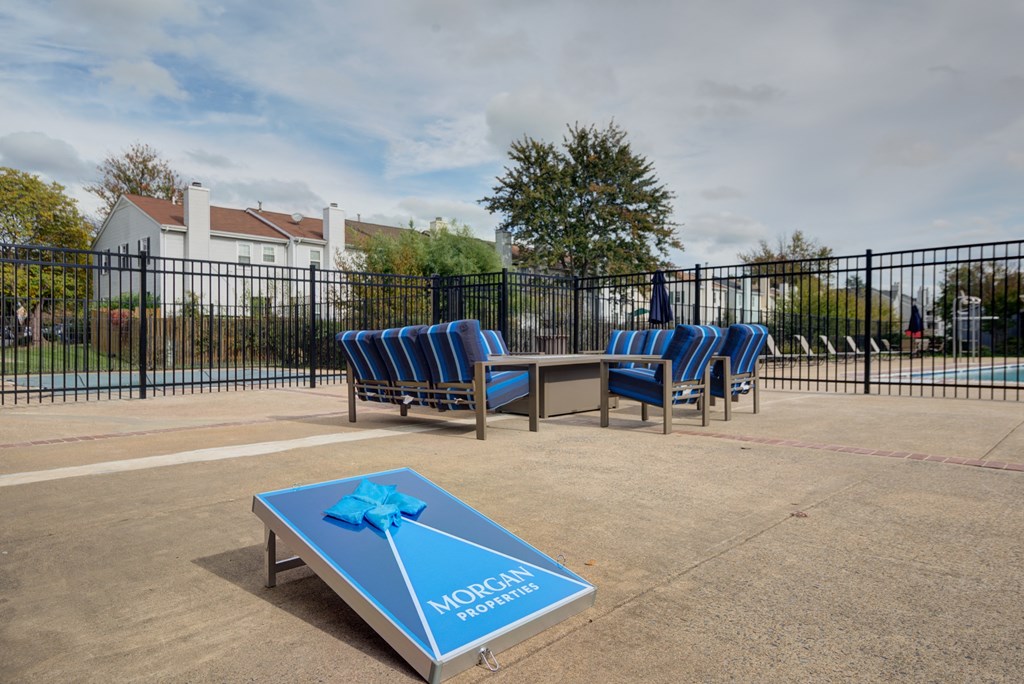 a pool with chairs and a table with a blue ribbon on it