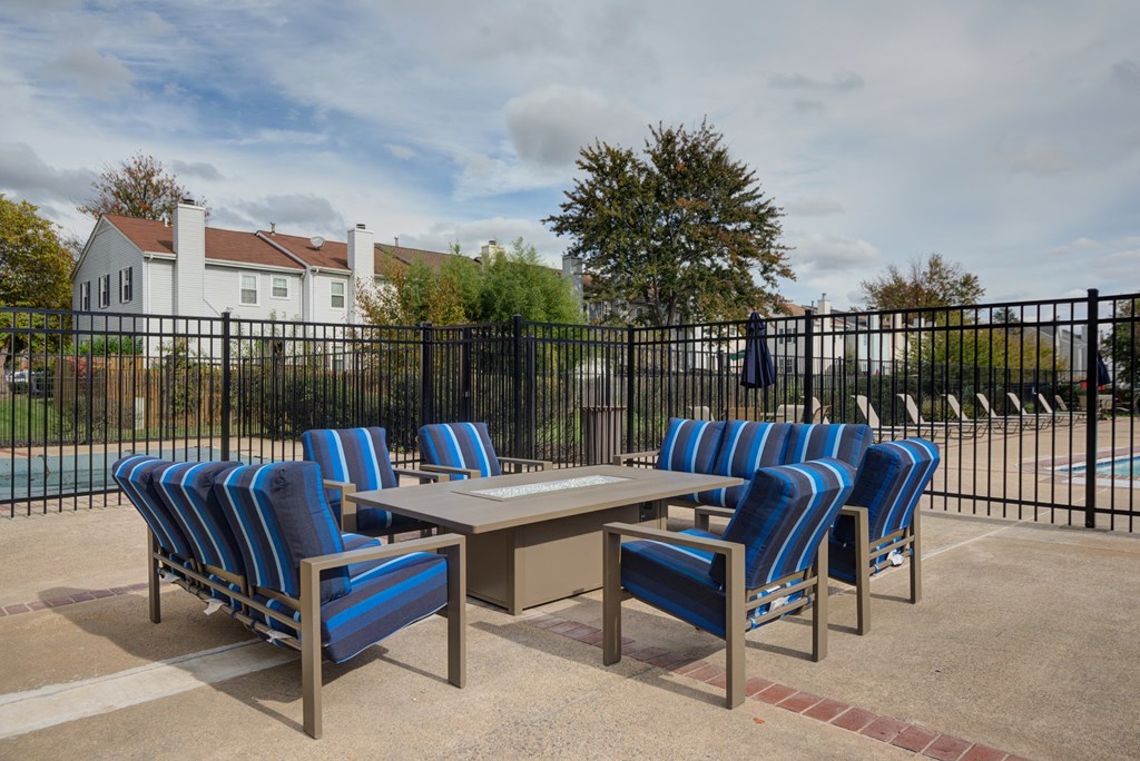 an outdoor patio with a table and chairs and a pool