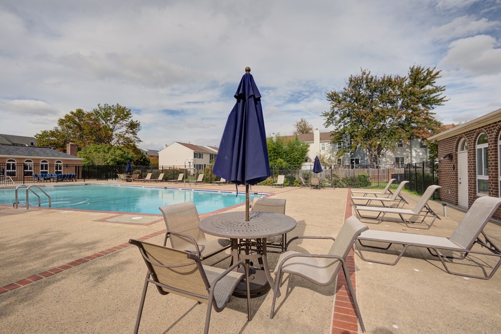 our apartments have a pool and patio with chairs and tables