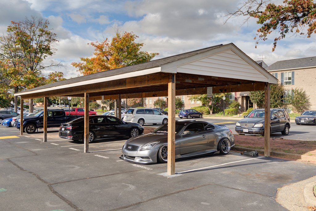 a parking lot with cars parked under a covered pavilion