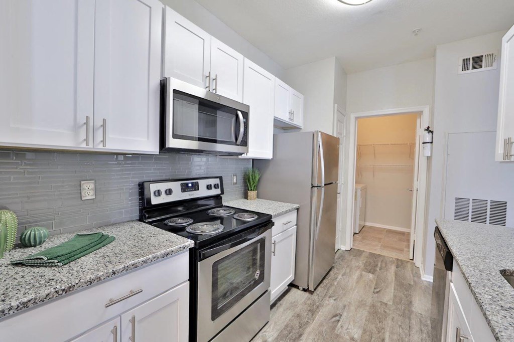 a kitchen with stainless steel appliances and white cabinets