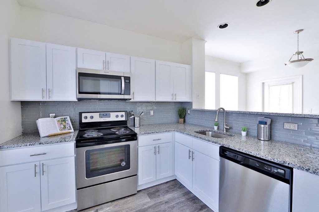 a kitchen with stainless steel appliances and white cabinets
