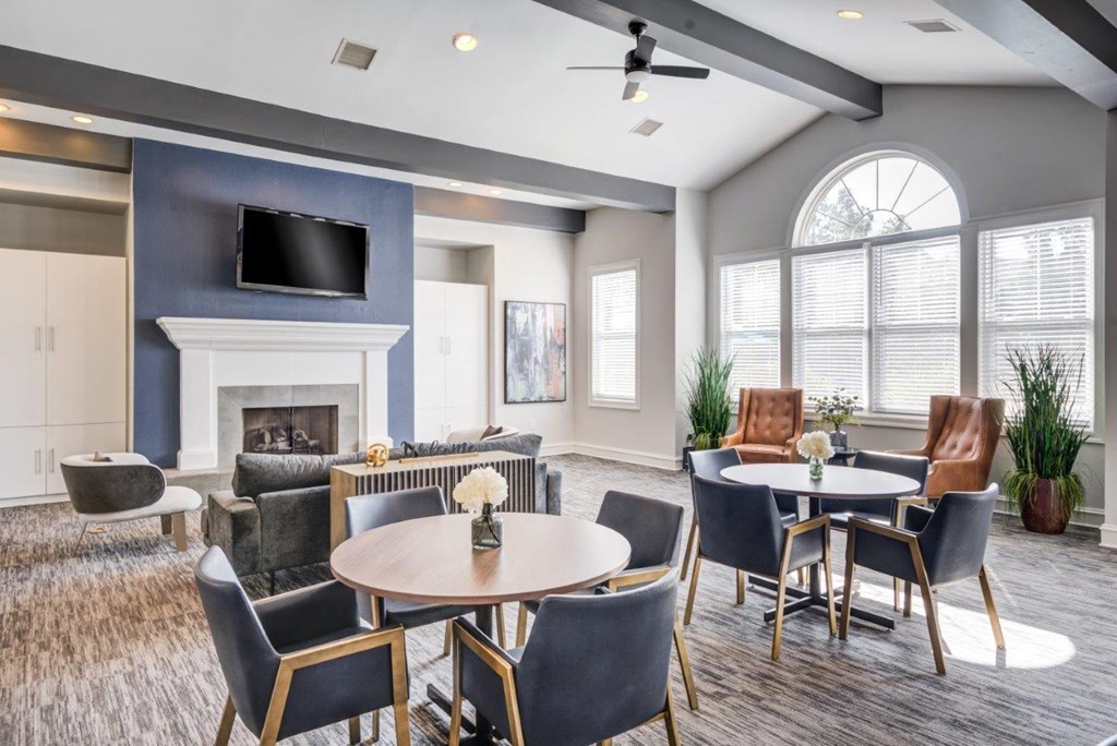 a living room with a fireplace and tables and chairs