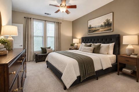 A bedroom with a large bed and a painting on the wall.