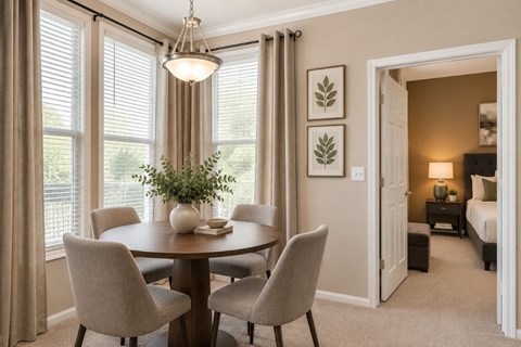 A dining room with a round table and chairs.