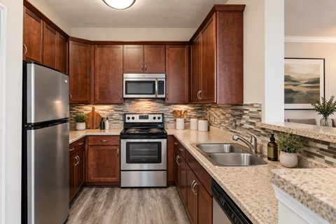 A kitchen with wooden cabinets and a stainless steel refrigerator.