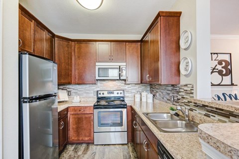 a kitchen with wooden cabinets and stainless steel appliances