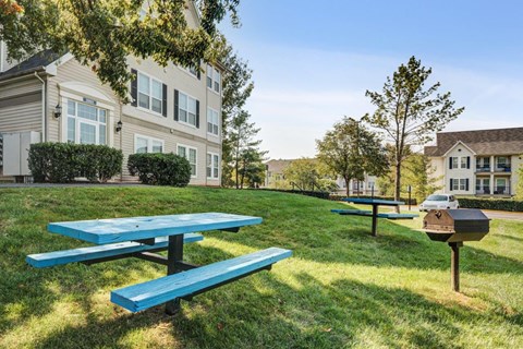 our picnic tables are in front of our building with a grill