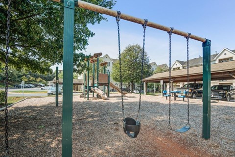 swings in a playground at a park with playground equipment