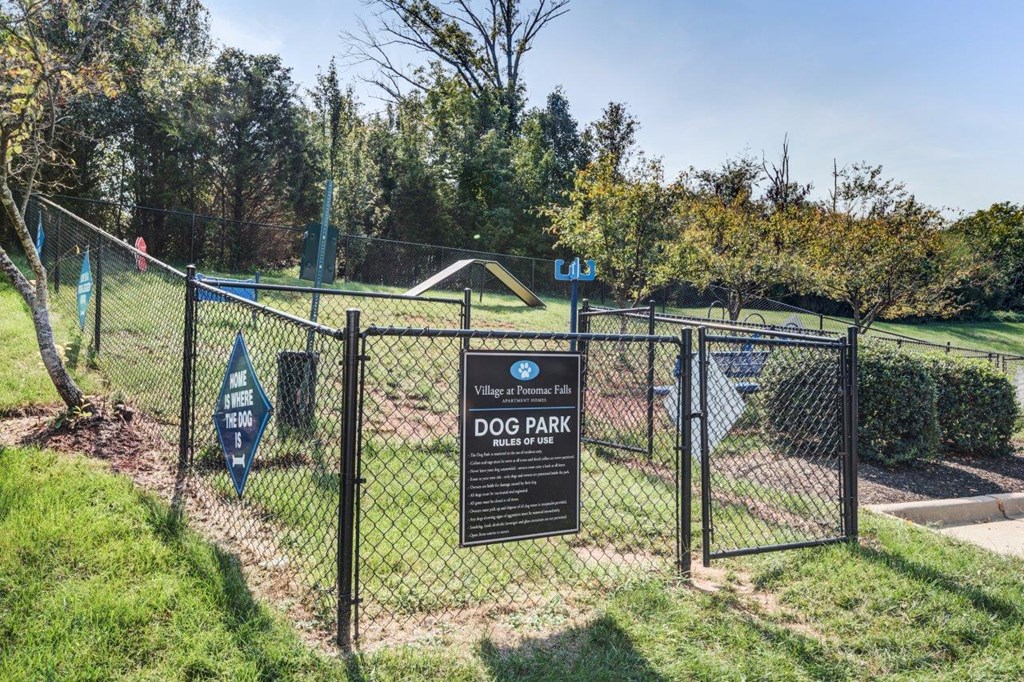 a dog park sign on a chain link fence with a gate