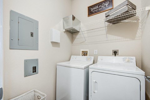 a white laundry room with two washes and a dryer