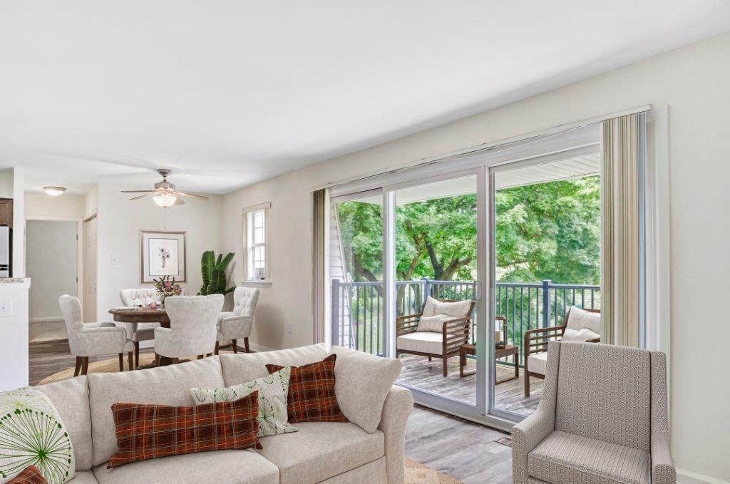a living room with a couch and chairs and a balcony