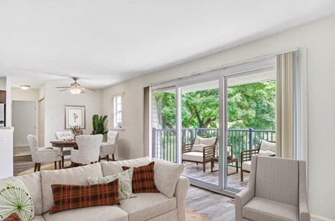 a living room with a couch and chairs and a balcony