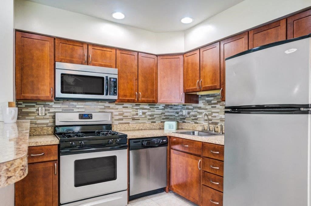 a kitchen with stainless steel appliances and wooden cabinets