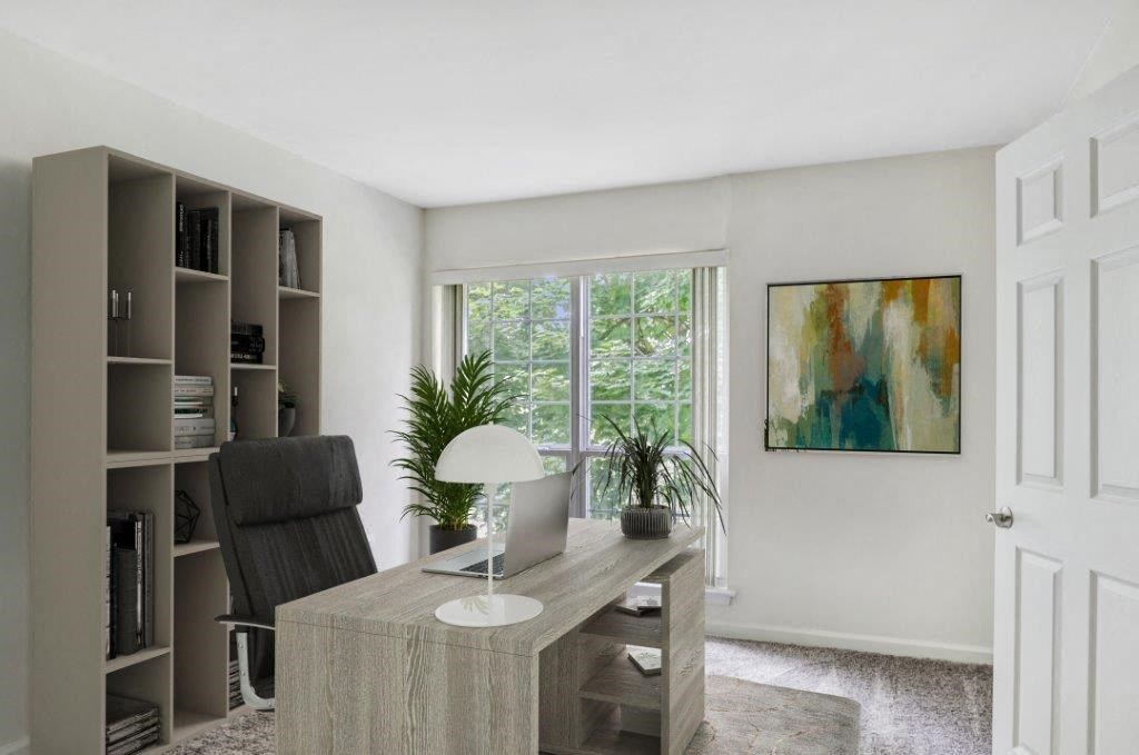 a home office with a desk and a window