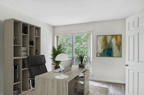 a home office with a desk and a window