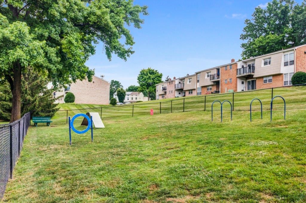 a playground in a park with trees and apartment buildings