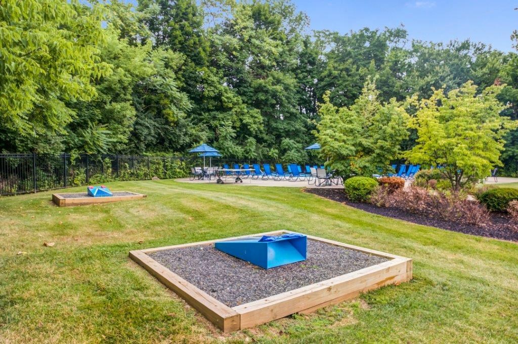 a fenced in backyard with a playground and a pool