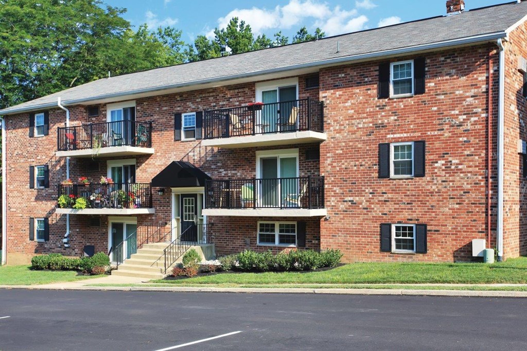 a red brick apartment building with balconies and stairs