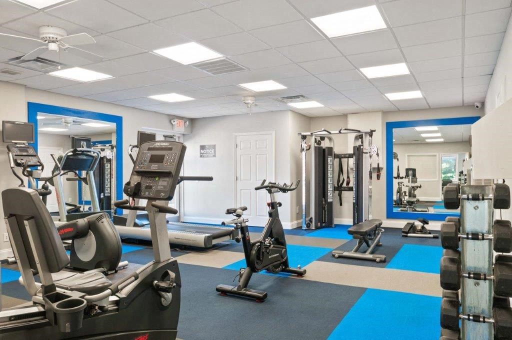 a gym with exercise equipment and mirrors in a building