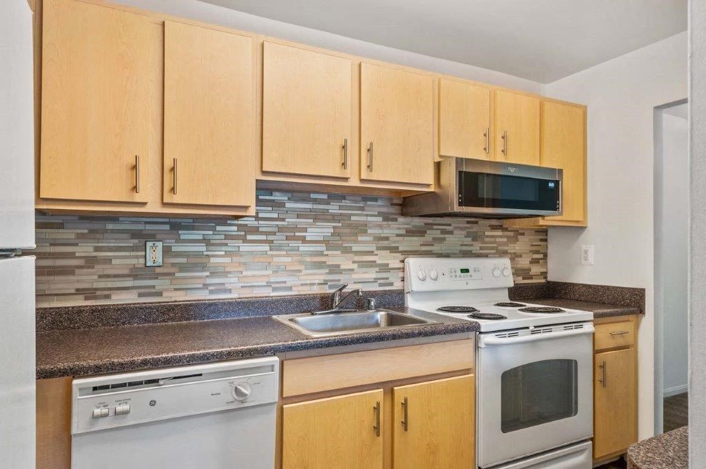 a kitchen with white appliances and wooden cabinets