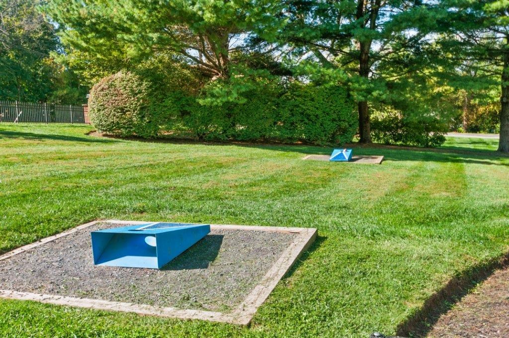 two blue ping pong tables in the middle of a grass field