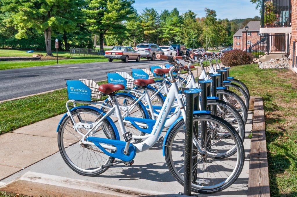 a row of blue bikes parked on a sidewalk