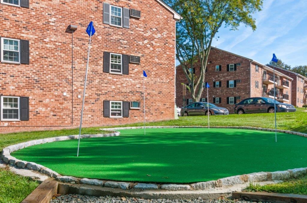 a putting green in front of a brick building