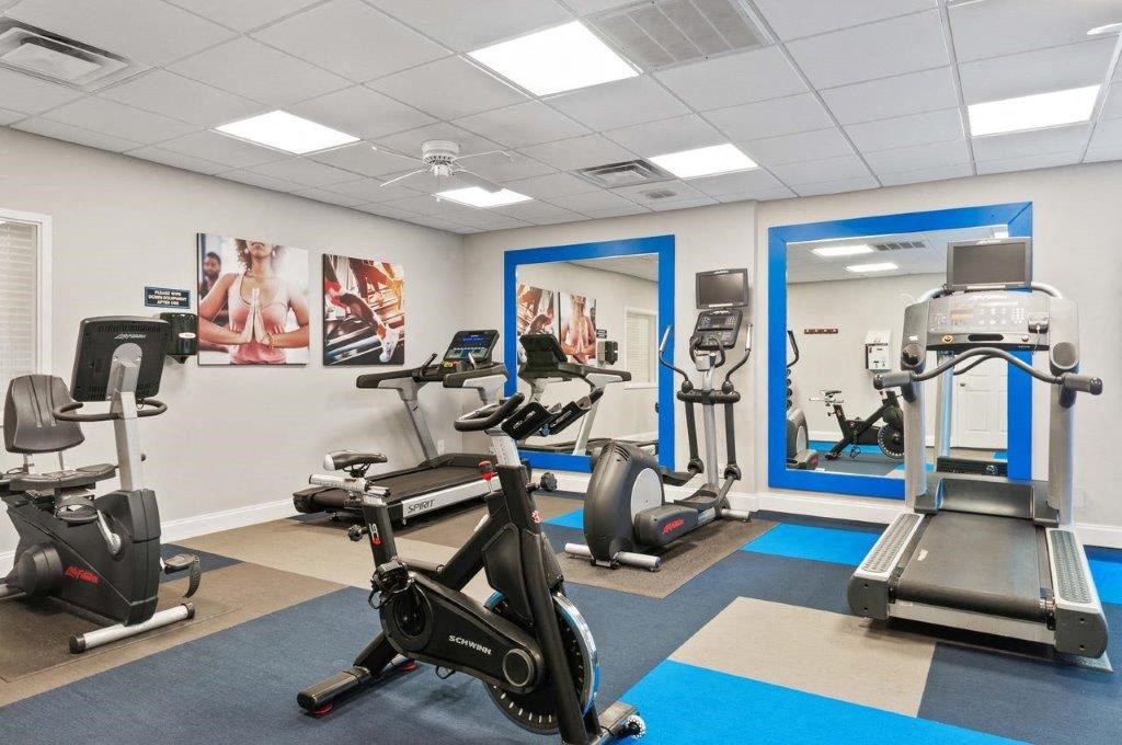 a gym with exercise equipment and paintings on the wall