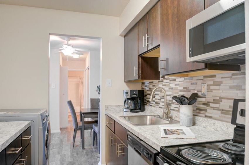 a kitchen with a sink and stove and a dining room