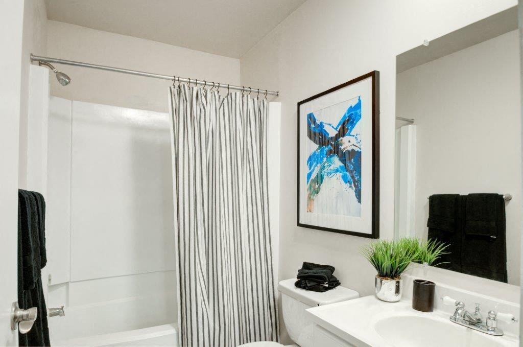 a bathroom with a shower curtain and a sink and a toilet
