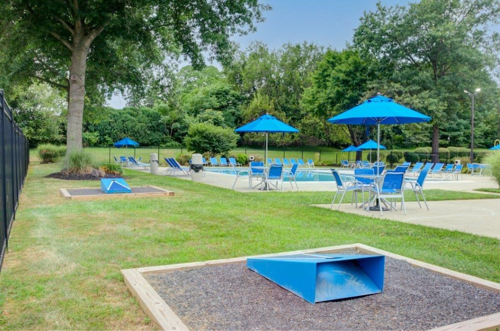 a picnic area with chairs and umbrellas and a pool