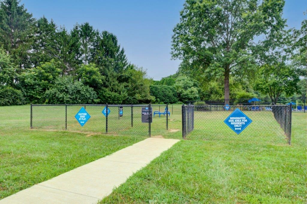 a dog park with blue signs on a chain link fence