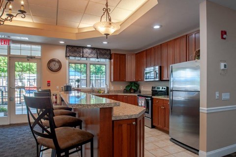 a kitchen with a bar and a stainless steel refrigerator