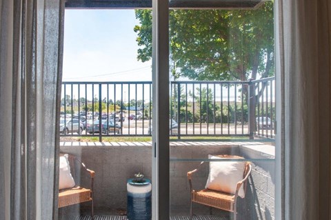 a view of the balcony from a window of a hotel room