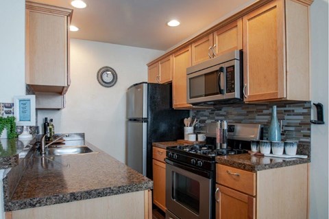 a kitchen with stainless steel appliances and granite counter tops