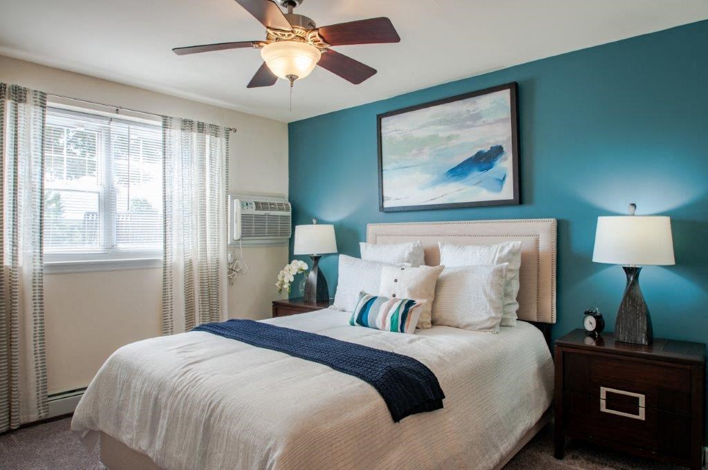a bedroom with a large bed and a ceiling fan